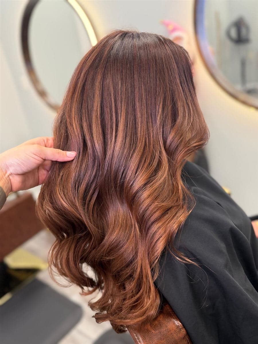 Melena castaño rojiza con ondas brillantes y reflejos dimensionales