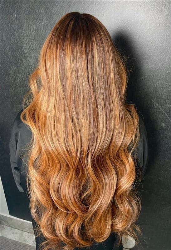 Melena extra larga en tonos rubio dorado y cobre con ondas, vista desde atrás